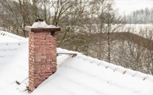 chimney on snowy roof with leaking issues