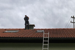 Roofing contractor performing a chimney inspection in the spring 